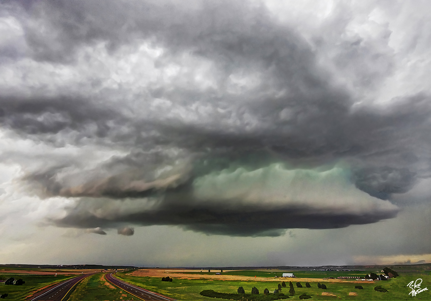 A severe storm hangs over highway I-80 near Sidney Nebraska June of 2013. The green hue you see on many severe storms is caused by hail in the core of the storm. 